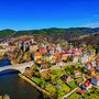 Loket Luftaufnahme einer bunten Kleinstadt mit Brücke und Fluss in einer hügeligen Landschaft.
