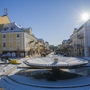 Franzensbad Winterliche Stadtstraße mit Brunnen und Sonne am klaren Himmel.