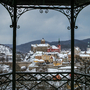 Loket Winterliche Stadtansicht mit Burg und Kirche, umrahmt von einem Pavillon.