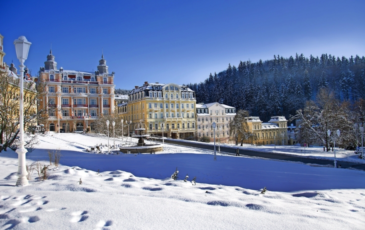  Marienbad Winterliche Ansicht einer Stadt mit historischen Gebäuden und schneebedeckten Bäumen.