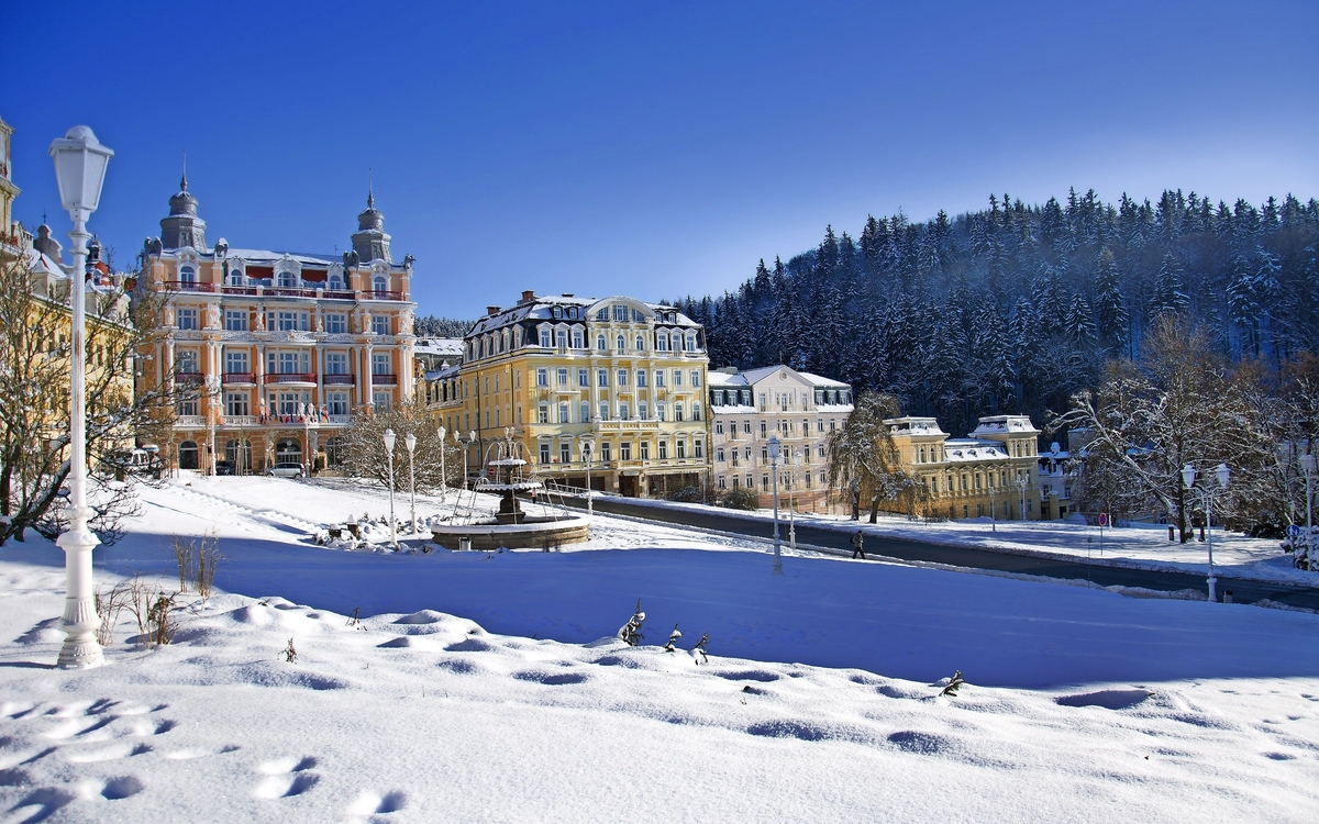  Marienbad Winterliche Ansicht einer Stadt mit historischen Gebäuden und schneebedeckten Bäumen.
