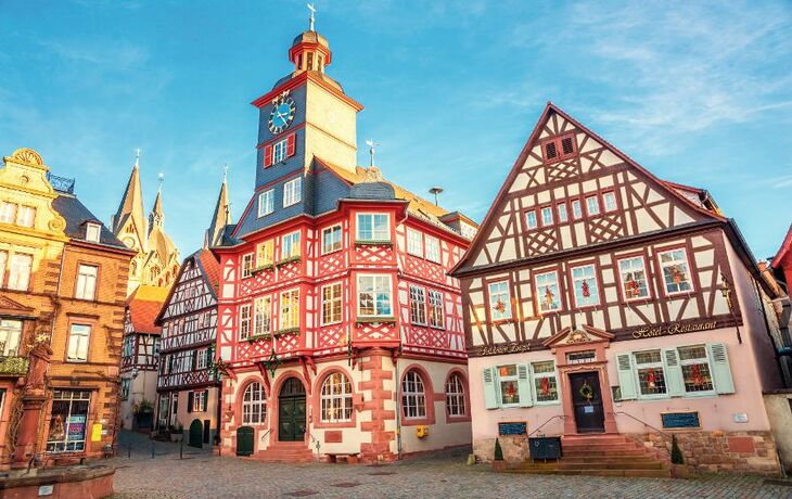 Historische Fachwerkhäuser mit Turm und Uhr in einer Altstadt.