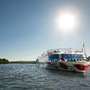 Ein Flussschiff der A-ROSA Flotte fährt bei Sonnenschein über die Rhone.