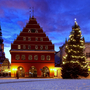 Historischer Marktplatz im Winter mit Weihnachtsbaum und beleuchtetem Gebäude. Greifswald
