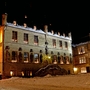 Historisches Gebäude bei Nacht, beleuchtet und von Schnee umgeben.