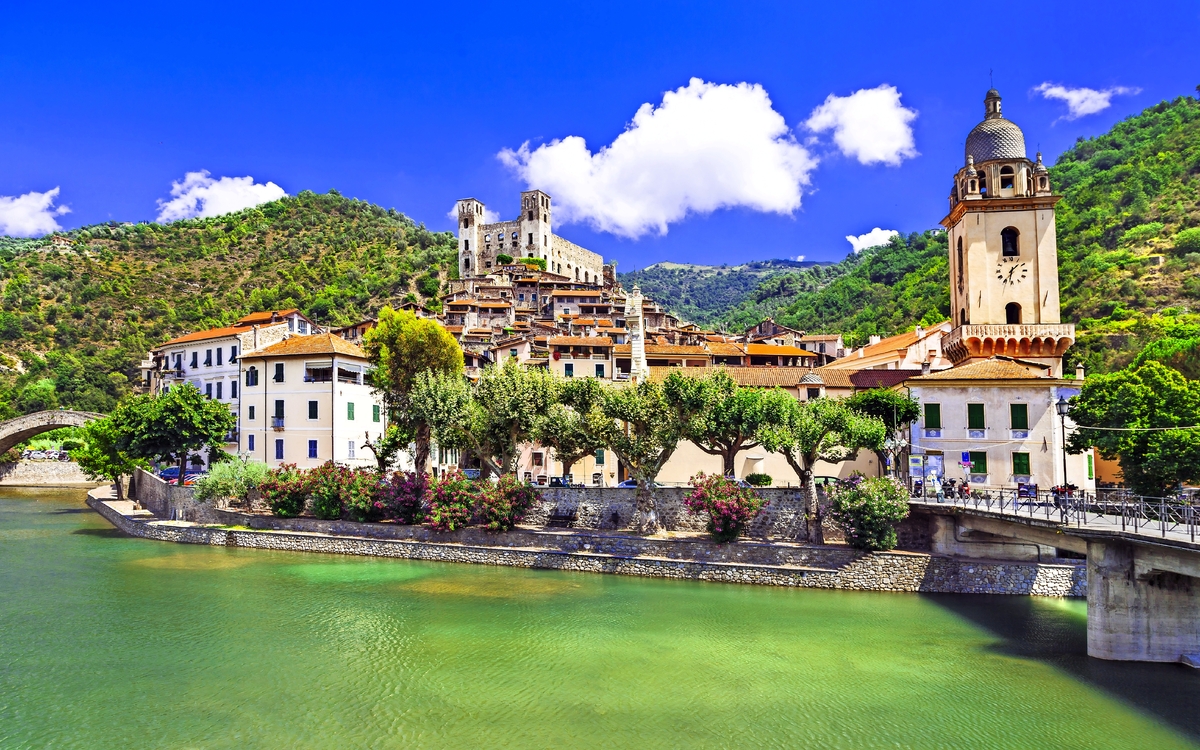 Dolceaqua Mittelalterliche Stadt mit Fluss und Hügeln im Hintergrund bei sonnigem Wetter.
