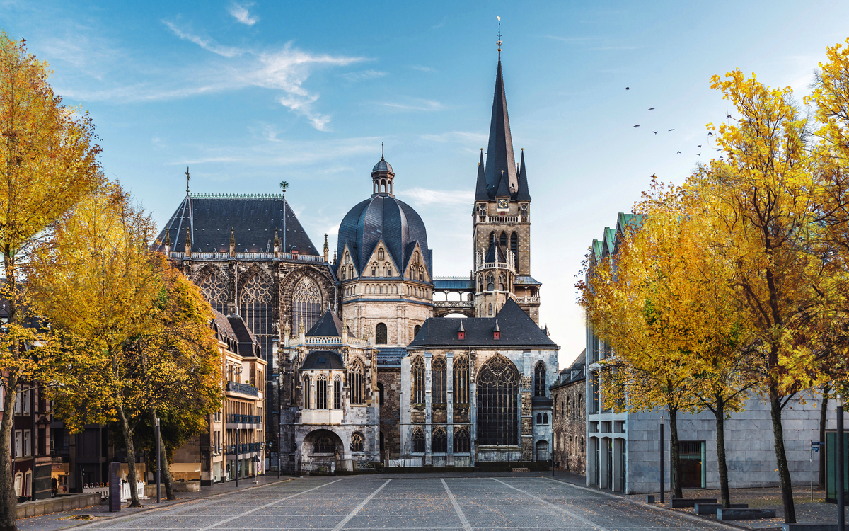Kirche mit gotischer Architektur und herbstlichen Bäumen im Vordergrund