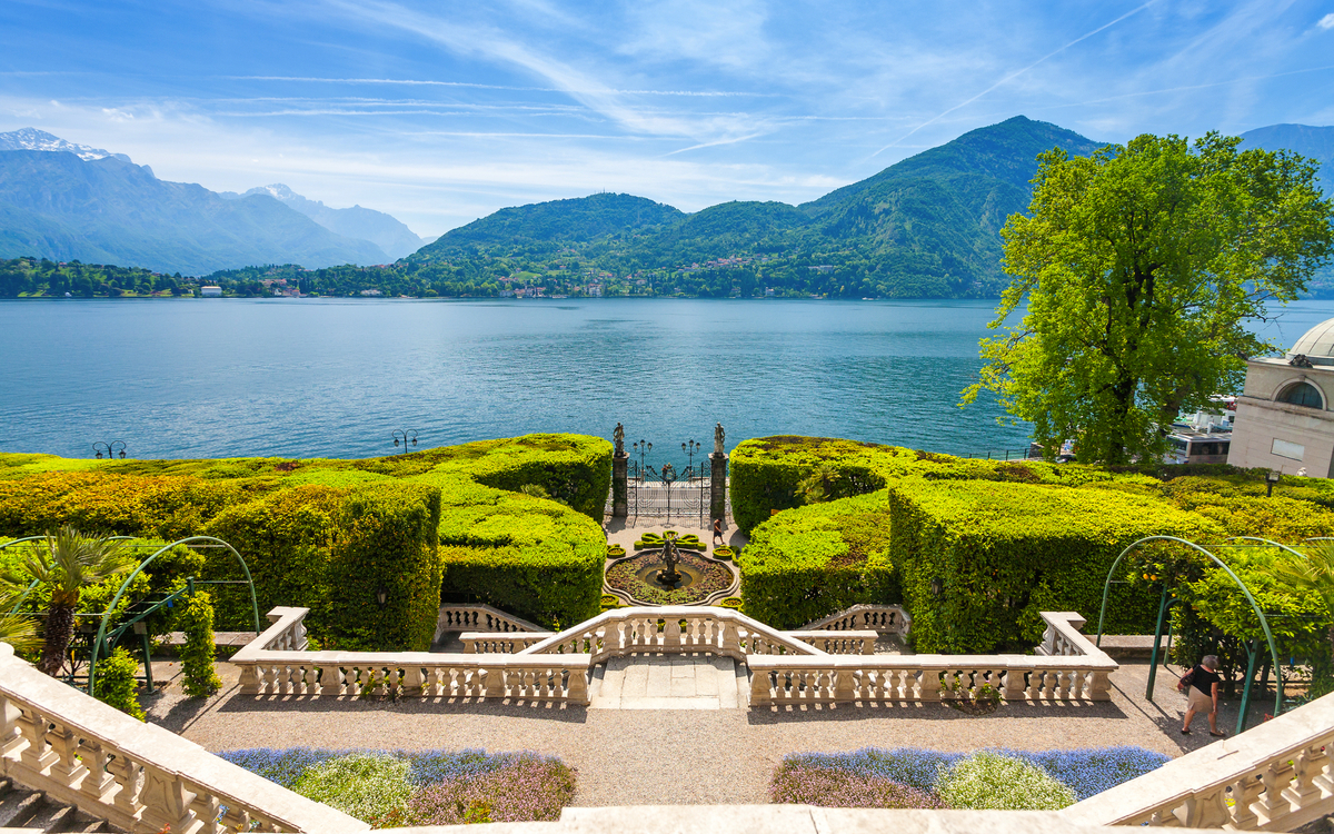 Terrasse mit Blick auf einen See und umliegende Berge bei klarem Himmel Vill Carlotta