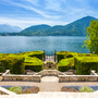 Terrasse mit Blick auf einen See und umliegende Berge bei klarem Himmel Vill Carlotta