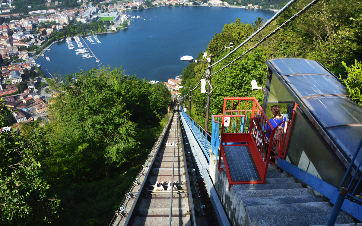 Standseilbahn mit Blick auf einen See und eine Stadt im Hintergrund.