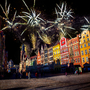 Feuerwerk über einem bunten, historischen Stadtplatz bei Nacht.