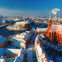 Winterliche Stadtansicht mit historischen Gebäuden und einer Kirche im Vordergrund.