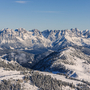Verschneite Berglandschaft mit klarer Sicht auf das Gebirgsmassiv unter blauem Himmel.