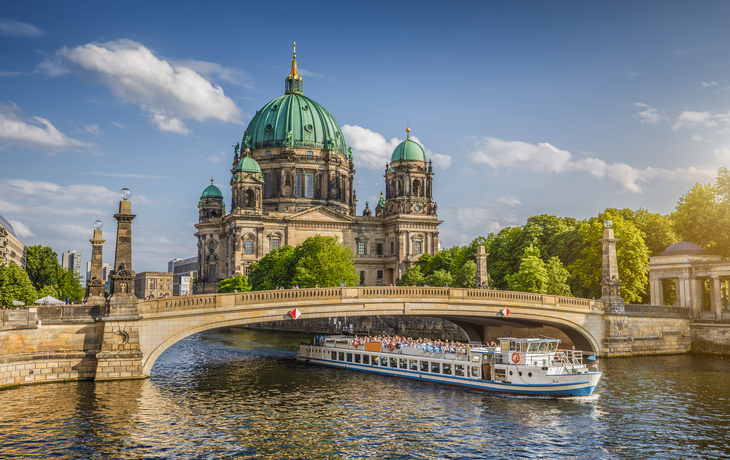 Berliner Dom mit Fluss und Ausflugsboot bei sonnigem Wetter im Vordergrund