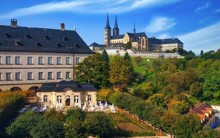 Historische Gebäude und Kloster auf einem Hügel bei sonnigem Wetter.