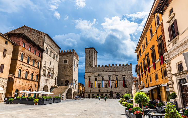 Historischer Platz mit alten Gebäuden und bewölktem Himmel in einer italienischen Stadt.