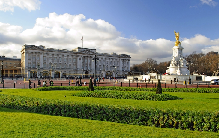 Buckingham Palace mit Garten und Denkmal bei Sonnenschein.