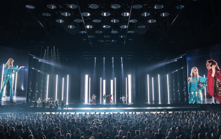 Bühnenbild der ABBA Voyage Show mit Projektionen, Publikum im Vordergrund