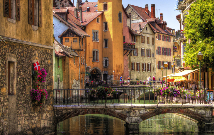 Historische Altstadt mit Brücke und Wasserkanal bei sonnigem Wetter.