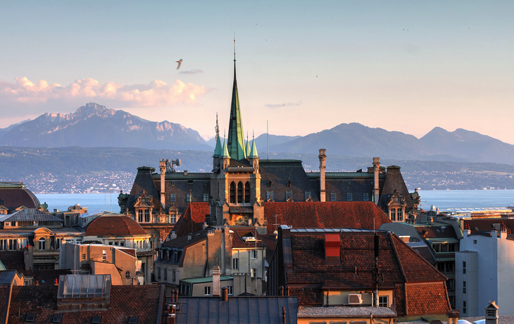 Panorama von Lausanne mit dem Genfersee im Hintergrund und Bergen im Hintergrund.