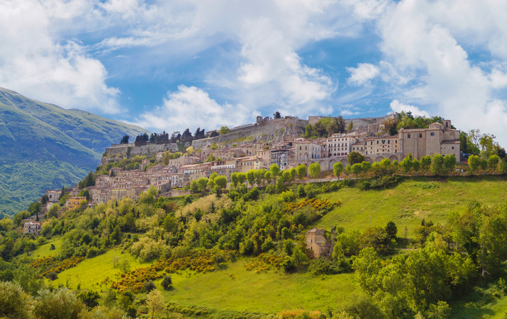 Blick auf die mittelalterliche Festung von Civitella del Tronto, umgeben von grüner Landschaft.