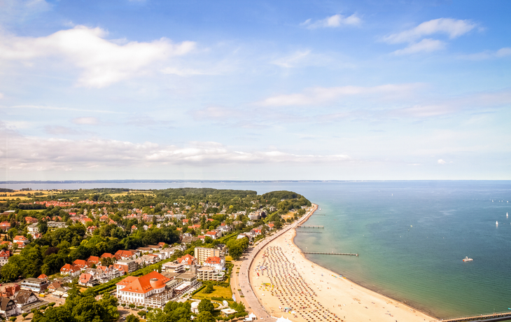 Luftaufnahme von Küstenstadt mit Strand, Meer und bewölktem Himmel