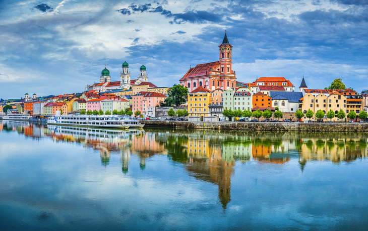Panoramablick auf eine Stadt mit Fluss und bunt bemalten Gebäuden.