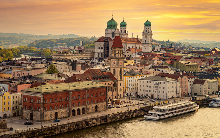Stadtansicht von Passau mit Donau und Dom bei Sonnenuntergang.