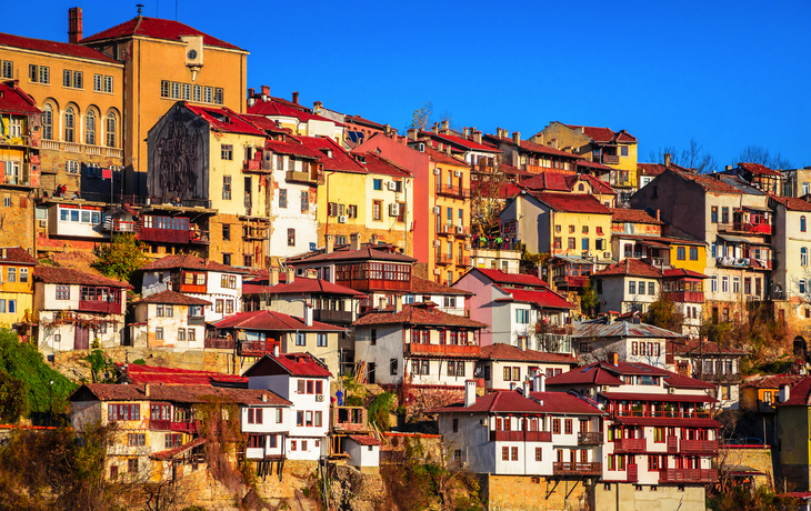 Bunte Häuser auf einem Hügel bei klarem Himmel.