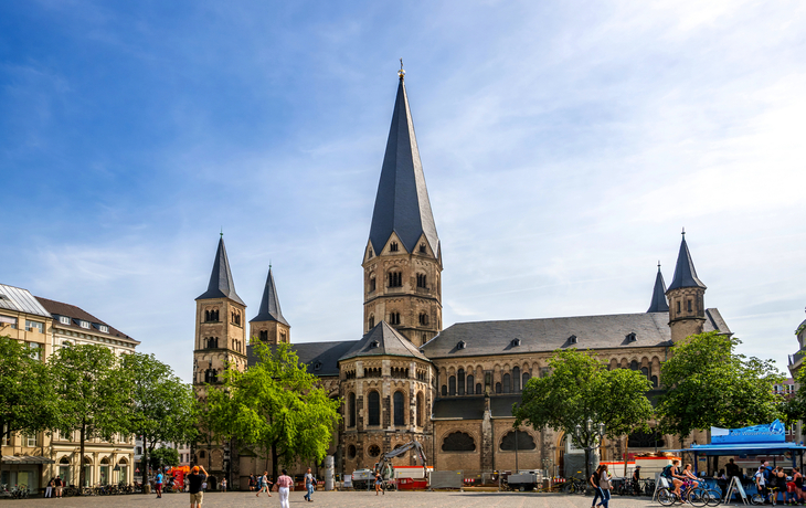 Historische Kirche mit hohen Türmen und umliegendem Platz bei blauem Himmel.