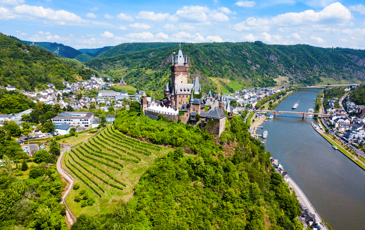Luftaufnahme der Reichsburg Cochem an der Mosel mit umliegender Landschaft.
