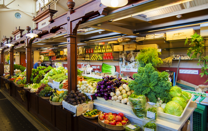 Ein Marktstand mit frischem Obst und Gemüse in einer Markthalle.