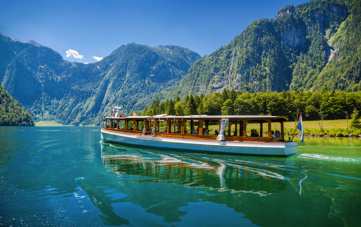 Boot auf einem malerischen See umgeben von Bergen und Wäldern