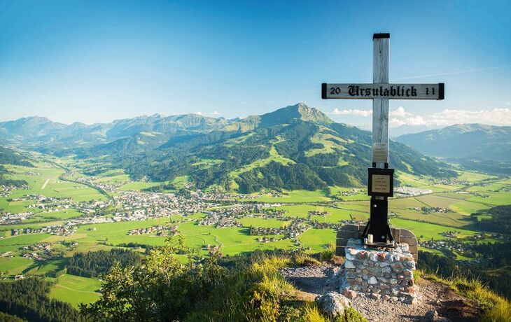 Aussicht von Ursulablick auf Kitzbüheler Alpen mit Gipfelkreuz im Vordergrund.