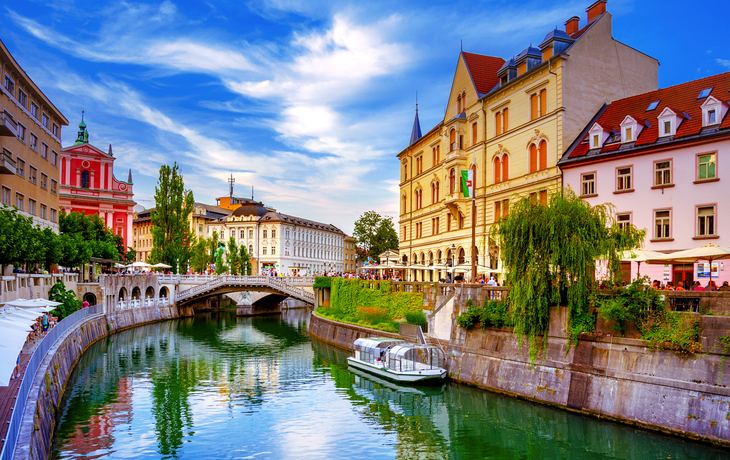 Fluss in der Stadt mit Brücke und historischen Gebäuden bei sonnigem Wetter