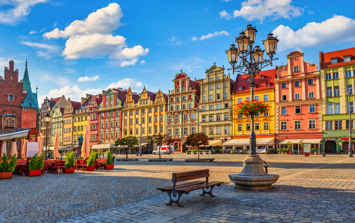 Bunte historische Gebäude am Marktplatz in Breslau bei sonnigem Wetter mit blauem Himmel.