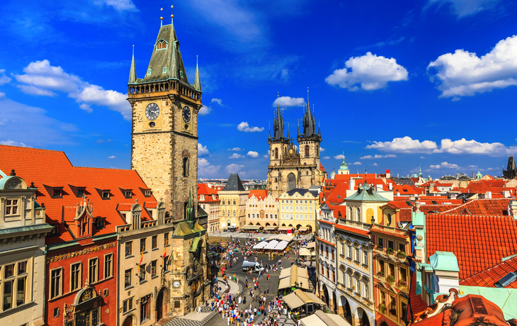 Historisches Stadtzentrum mit Turm und gotischer Kirche bei blauem Himmel.