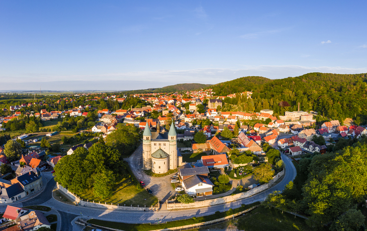 Luftaufnahme einer kleinen Stadt mit Kirche und umliegender Landschaft.