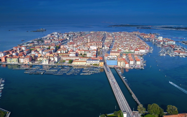 Luftaufnahme einer Stadt auf einer Insel mit Brücken und Hafenanlagen.