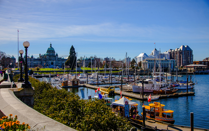 Hafen mit Yachten und Blick auf Gebäude und blauen Himmel.