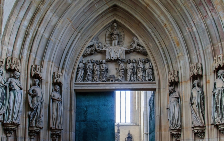 Steinerne Kirchentür des Magdeburger Doms mit gotischen Skulpturen und Reliefs.
