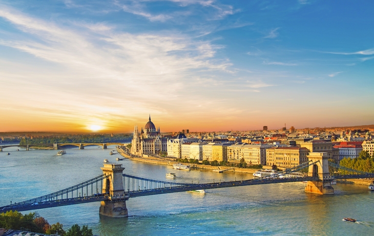 Panoramablick auf Budapest bei Sonnenuntergang mit der Kettenbrücke und dem Parlamentsgebäude am Ufer der Donau.