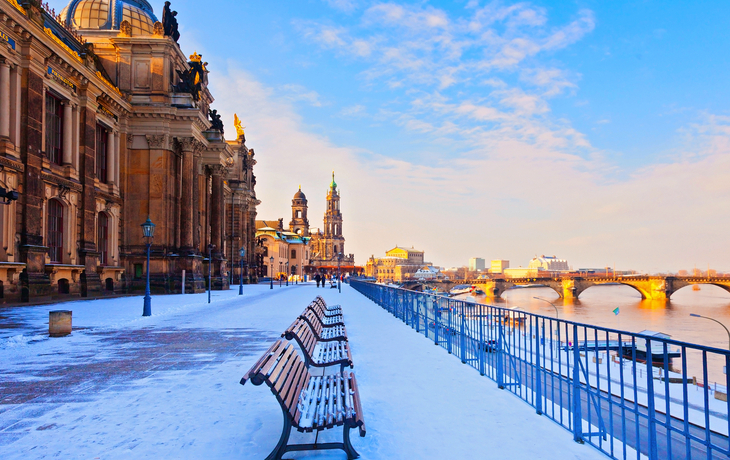 Verschneite Uferpromenade in Dresden mit Blick auf die historische Altstadt.
