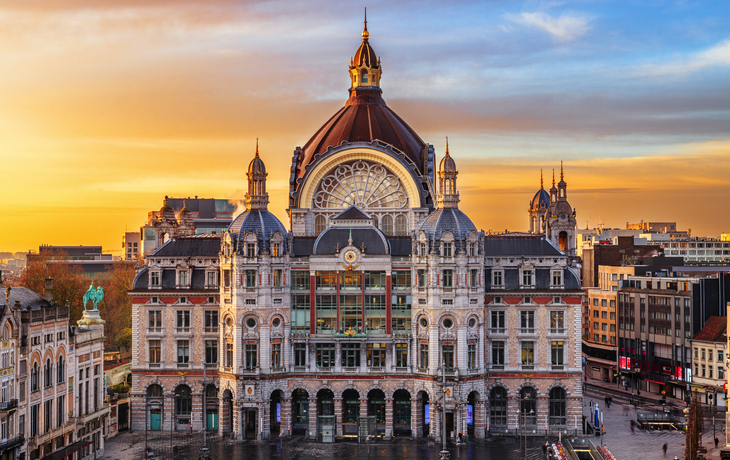 Belgisches Stadtbild mit dem Hauptbahnhof von Antwerpen bei Sonnenuntergang.
