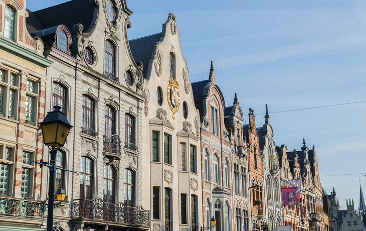 Reihe historischer Gebäude mit verzierten Fassaden bei klarem Himmel.