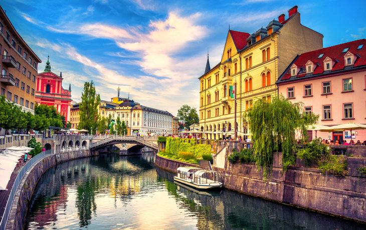 Fluss mit Brücke, Altstadtgebäude, Boot, blauer Himmel.