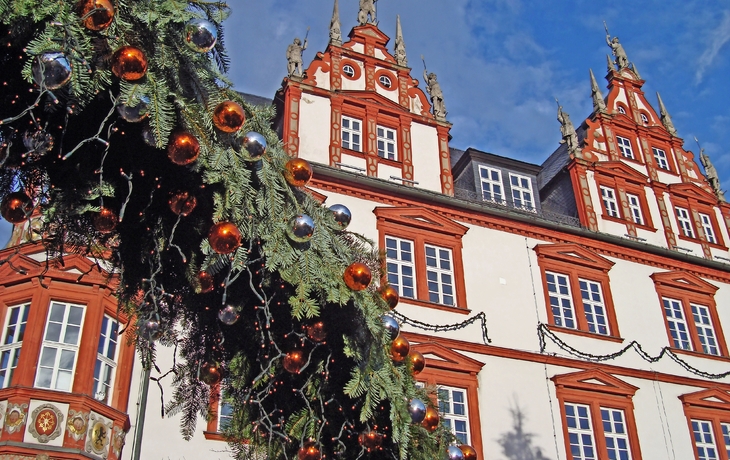 Fachwerkhaus mit weihnachtlicher Dekoration und blauem Himmel.
