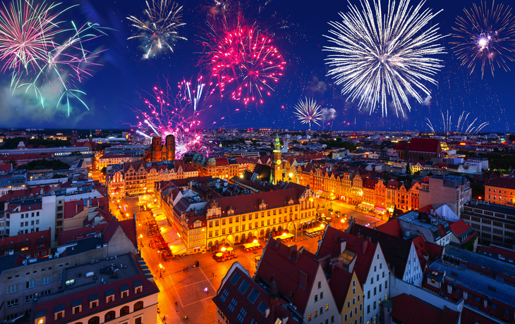 Stadtpanorama bei Nacht mit leuchtendem Feuerwerk am Himmel