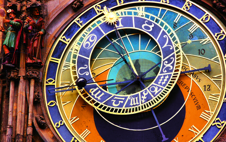 Astronomische Uhr mit farbenfrohen, detaillierten Zifferblättern und Verzierungen.